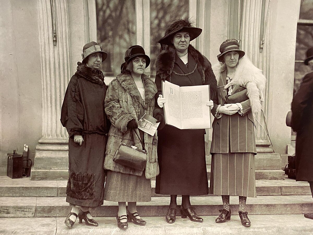 Annie Hughes Griffiths yn dal copi o’r Apêl y tu allan i’r Tŷ Gwyn yn Washington yn dilyn eu cyfarfod â’r Arlywydd Calvin Coolidge yn 1924, ochr yn ochr â Gladys Thomas, Mary Ellis ac Elined Prys (Ch-Dd).