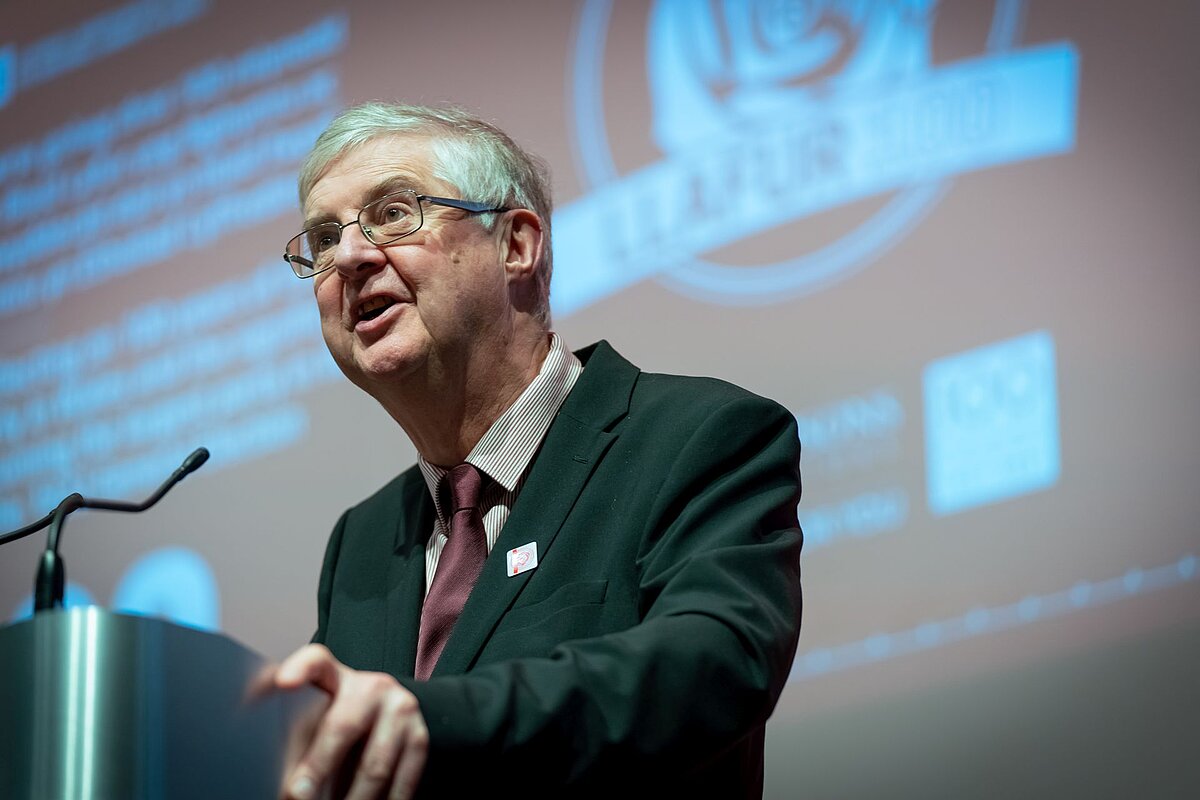 Y Gwir Anrhydeddus Mark Drakeford AS yn siarad o lwyfan