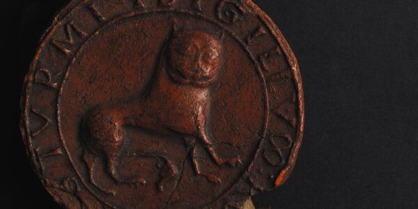 Llun agos o sêl ganoloesol wedi'i chastio mewn cwyr coch ac yn cynnwys arwydd llew