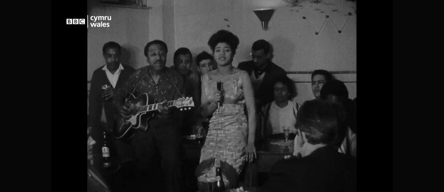 A screengrab from a black and white film of musicians performing at the Ghana Club, including Clara Graham and Vic Parker.